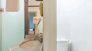 Ein Badezimmer mit Marmorwaschbecken, Fön, Toilette und Handtuchhalter.