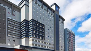 A multi-story hotel with a modern design, featuring a prominent logo on the top. - ibis budget Curitiba Centro (Curitiba)