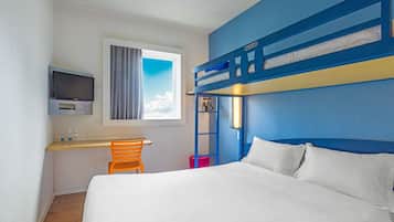 A bunk bed room with a desk, chair, and TV.