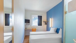A hotel room with two beds, a desk, a TV, and a window with curtains. - ibis budget Curitiba Centro (Curitiba)