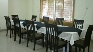 A conference room with a long table, chairs, and a window with blinds.