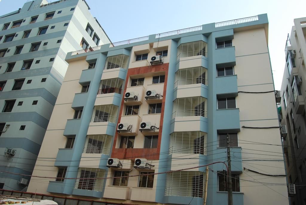 A multi-story building with balconies, air conditioning units, and a visible power line.