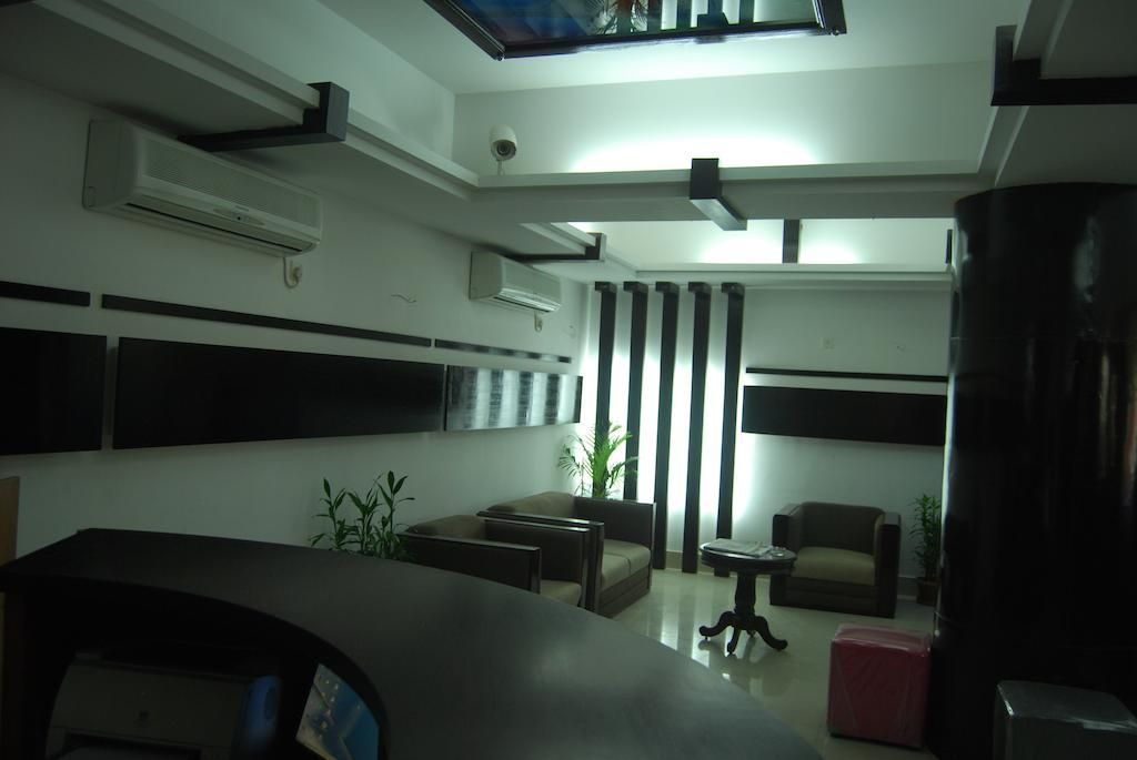 A modern interior with a reception desk, seating area, and air conditioning units.