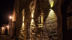 Un bâtiment en pierre, doté d’enseignes lumineuses et bordé d’un chemin pavé.