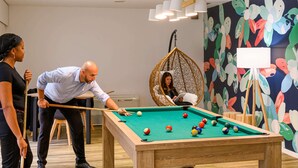 A pool table in a room with a colorful mural, a hanging chair, and a whiteboard. - Ibis Styles Parc des Expositions de Villepinte (Villepinte)