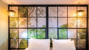 A bedroom with a large window, two bedside lamps, and a bed with white linens. - Ibis Styles Parc des Expositions de Villepinte (Villepinte)