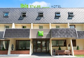 A hotel named "ibis Styles" with a modern design, featuring a flat roof, large windows, and a welcoming entrance.