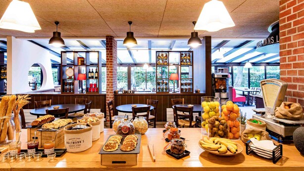 A bakery counter with pastries, bread, and jars of preserves. - Ibis Styles Parc des Expositions de Villepinte (Villepinte)