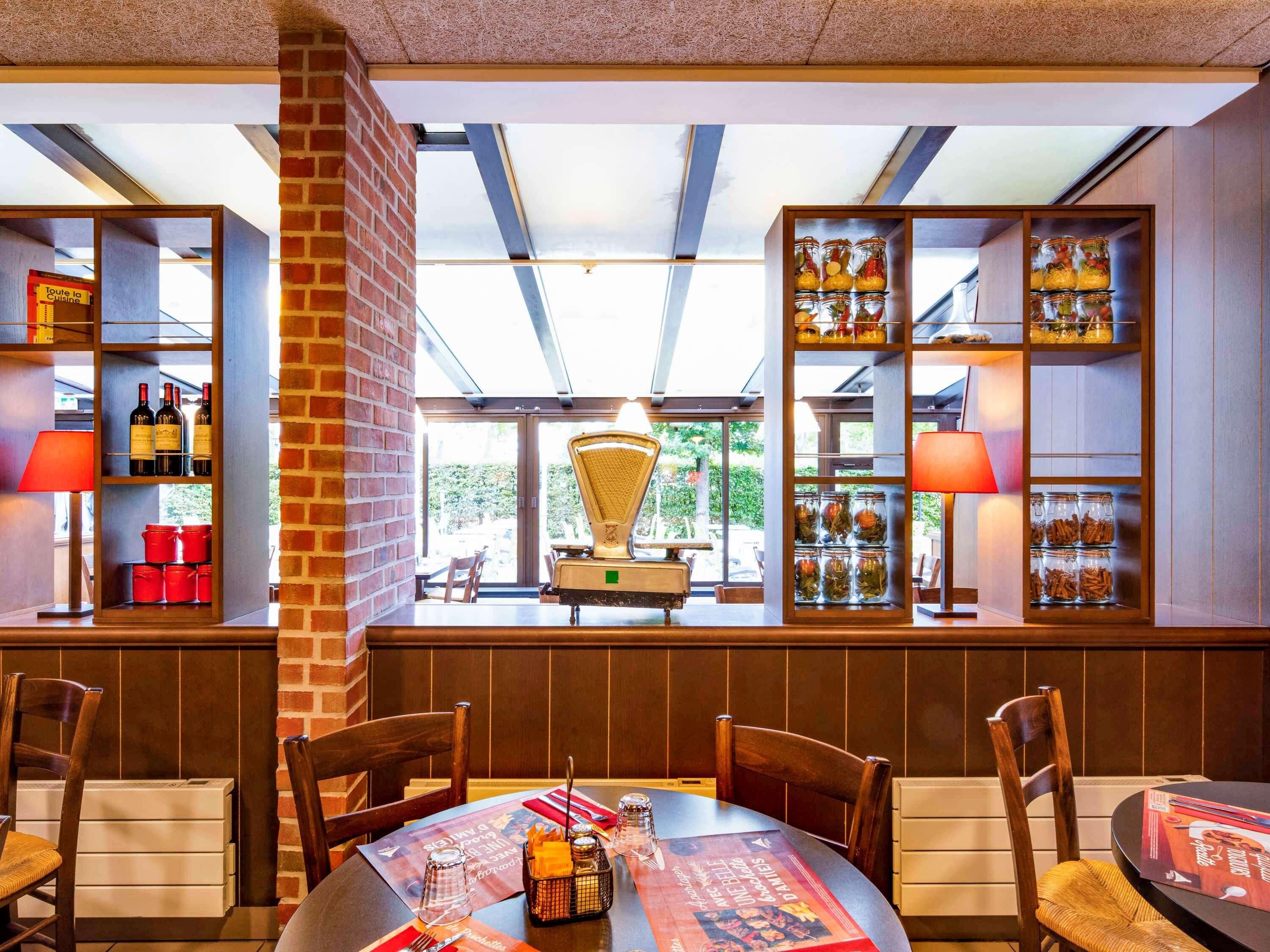 Un restaurante con pared de ladrillo, estanterías de madera y una mesa lista para comer.