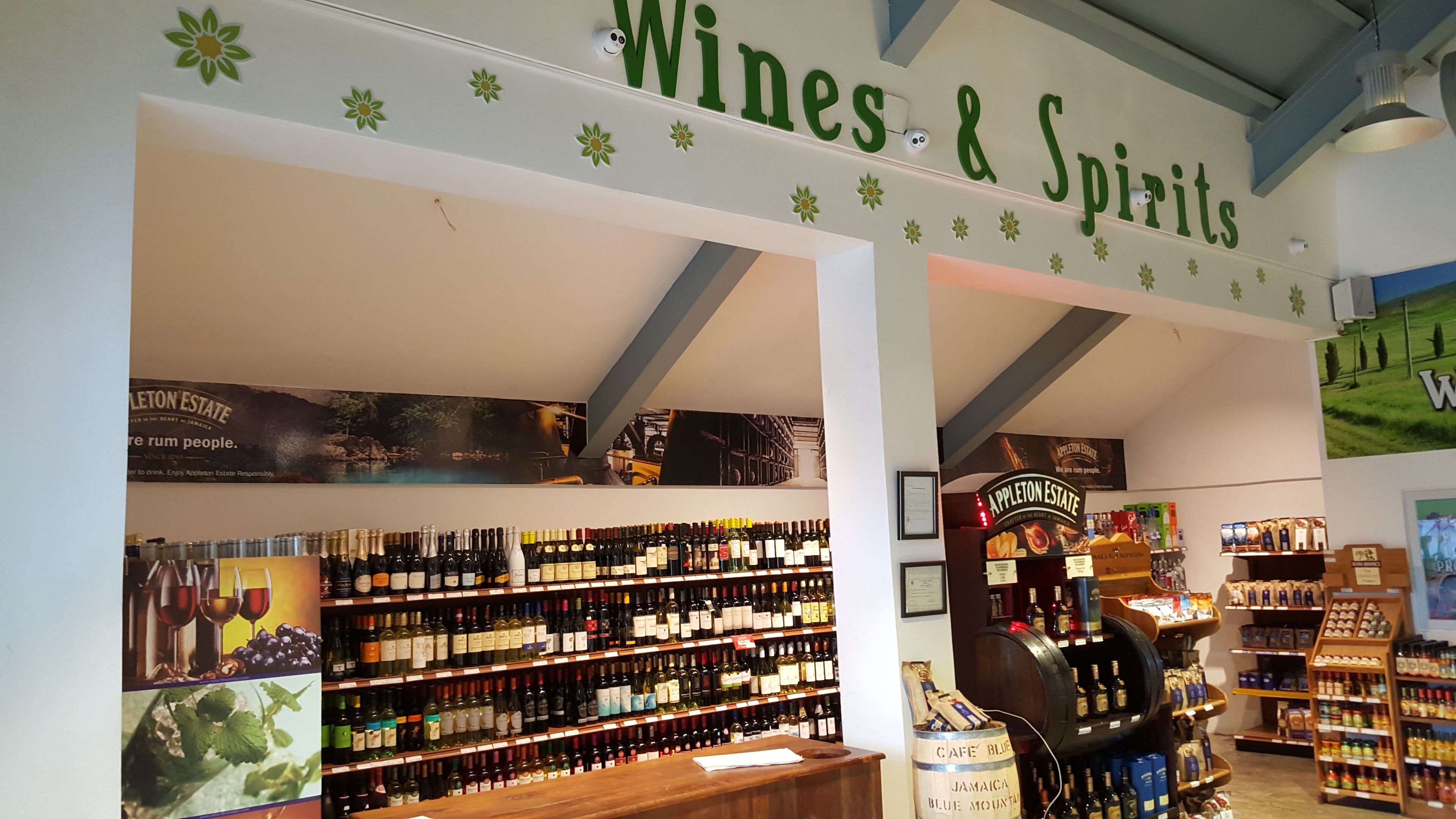 A wine and spirits store with shelves of various bottles and a section for Appleton Estate rum.