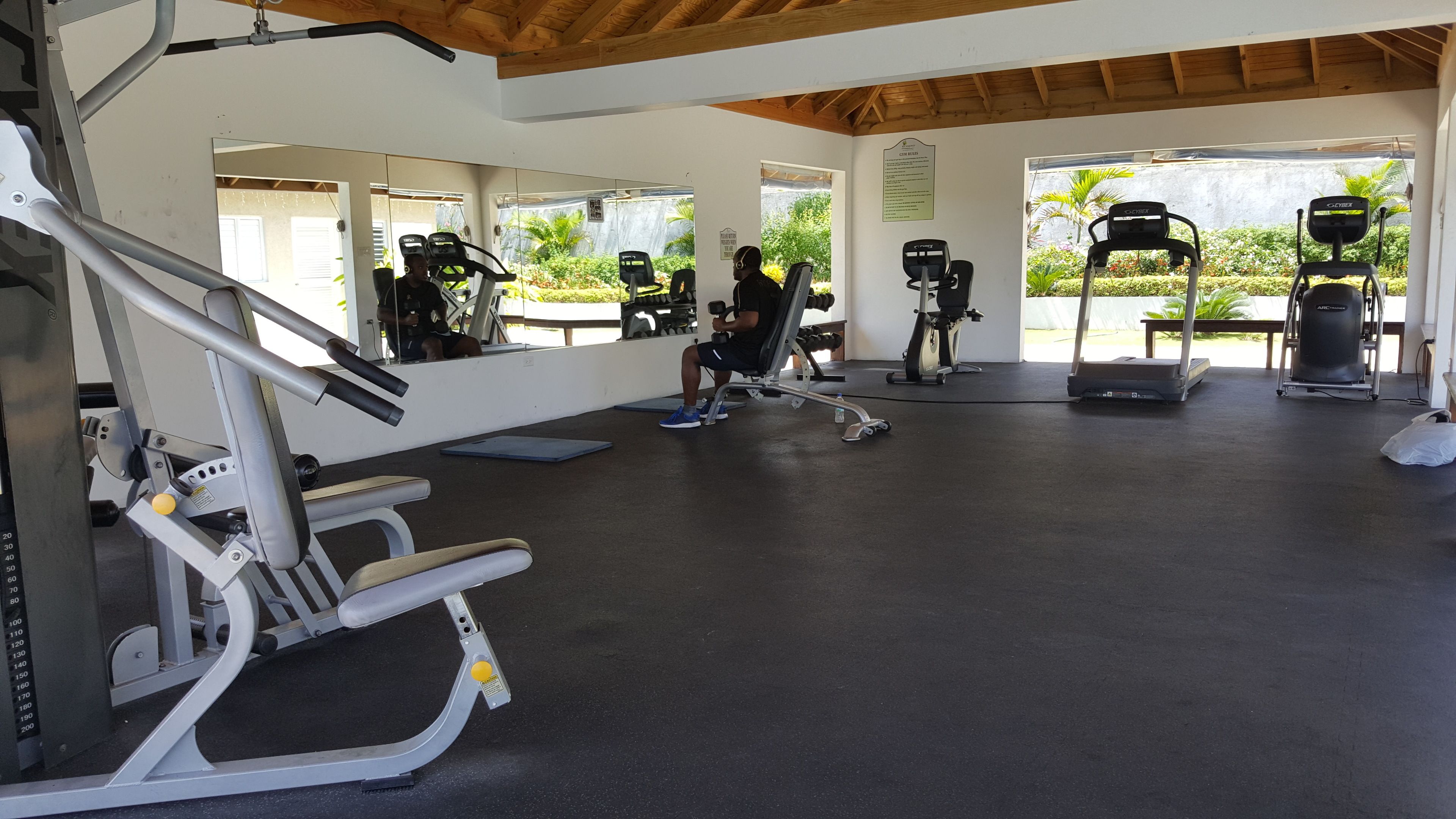 A gym with various exercise machines, including a rowing machine, a stationary bike, and a treadmill.