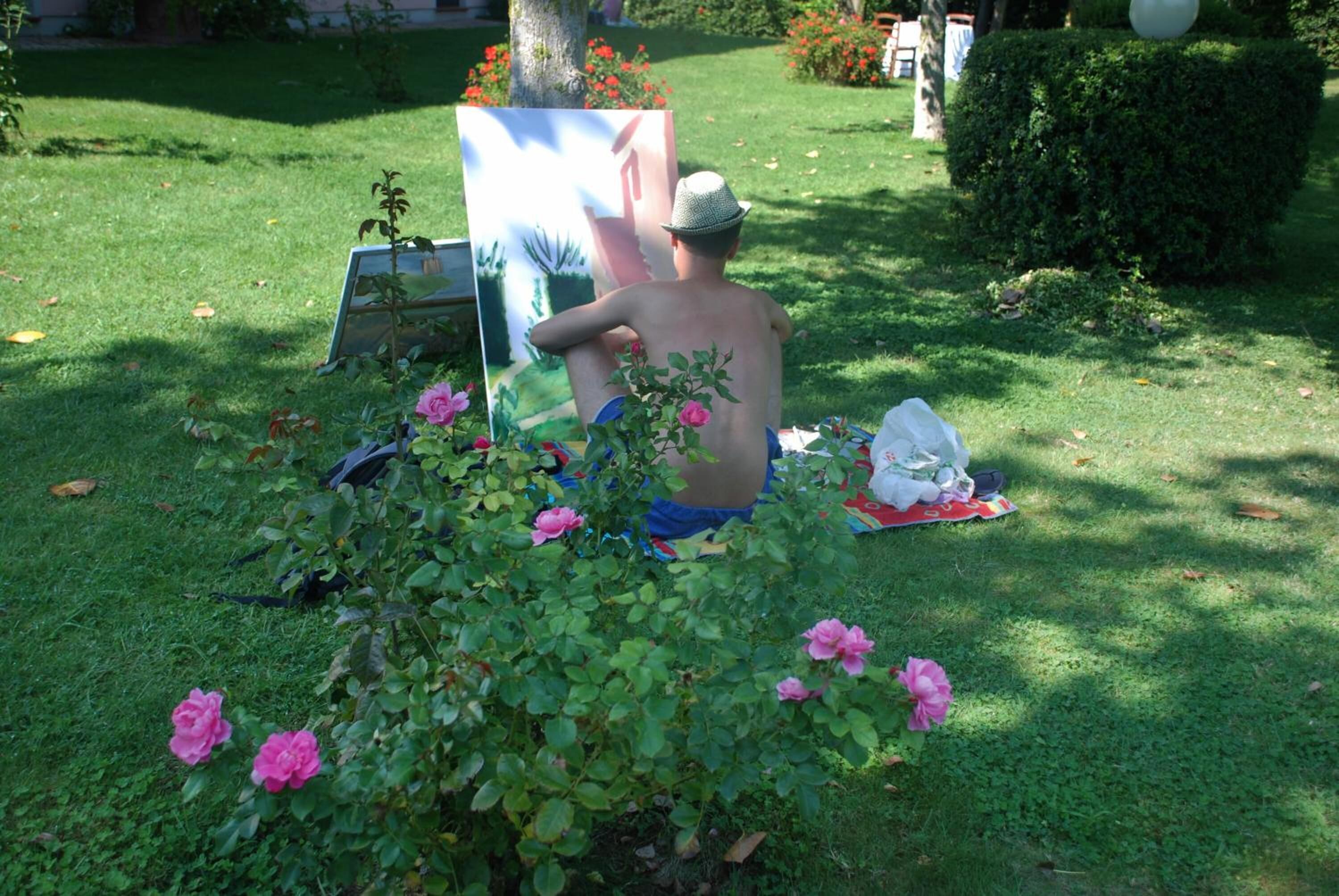 A person painting a portrait outdoors on a sunny day.