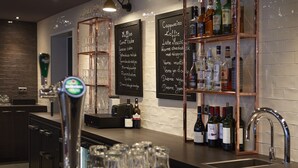 A bar area with a tap, glasses, and a shelf with bottles. - Hotel Lion d'Or (Haarlem)