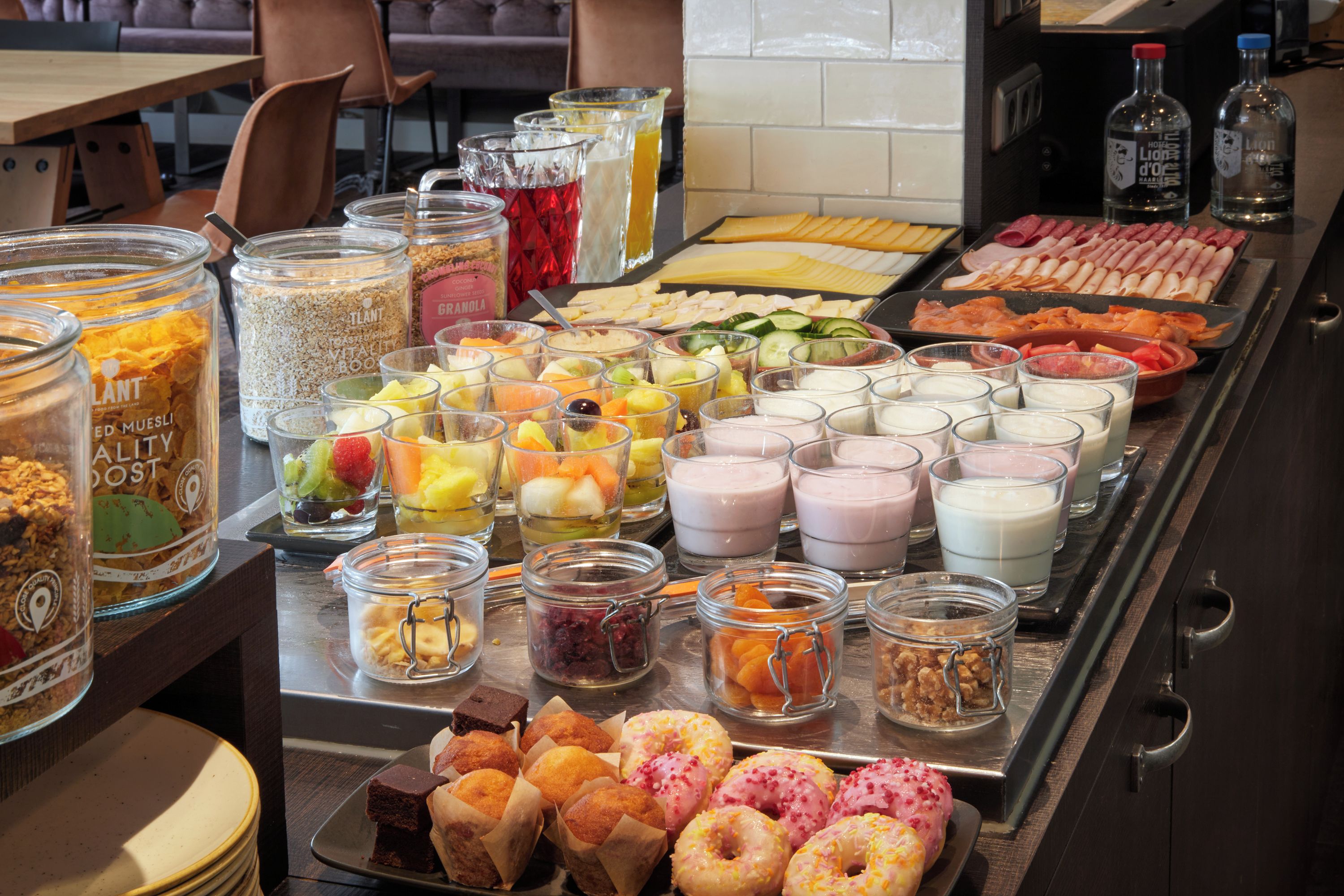 Un buffet proposant une variété de plats, notamment des fruits, des fromages, des viandes et des pâtisseries.