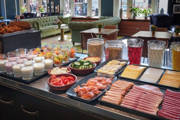 A buffet with various food options including meats, cheeses, and fruits. - Hotel Lion d'Or (Haarlem)