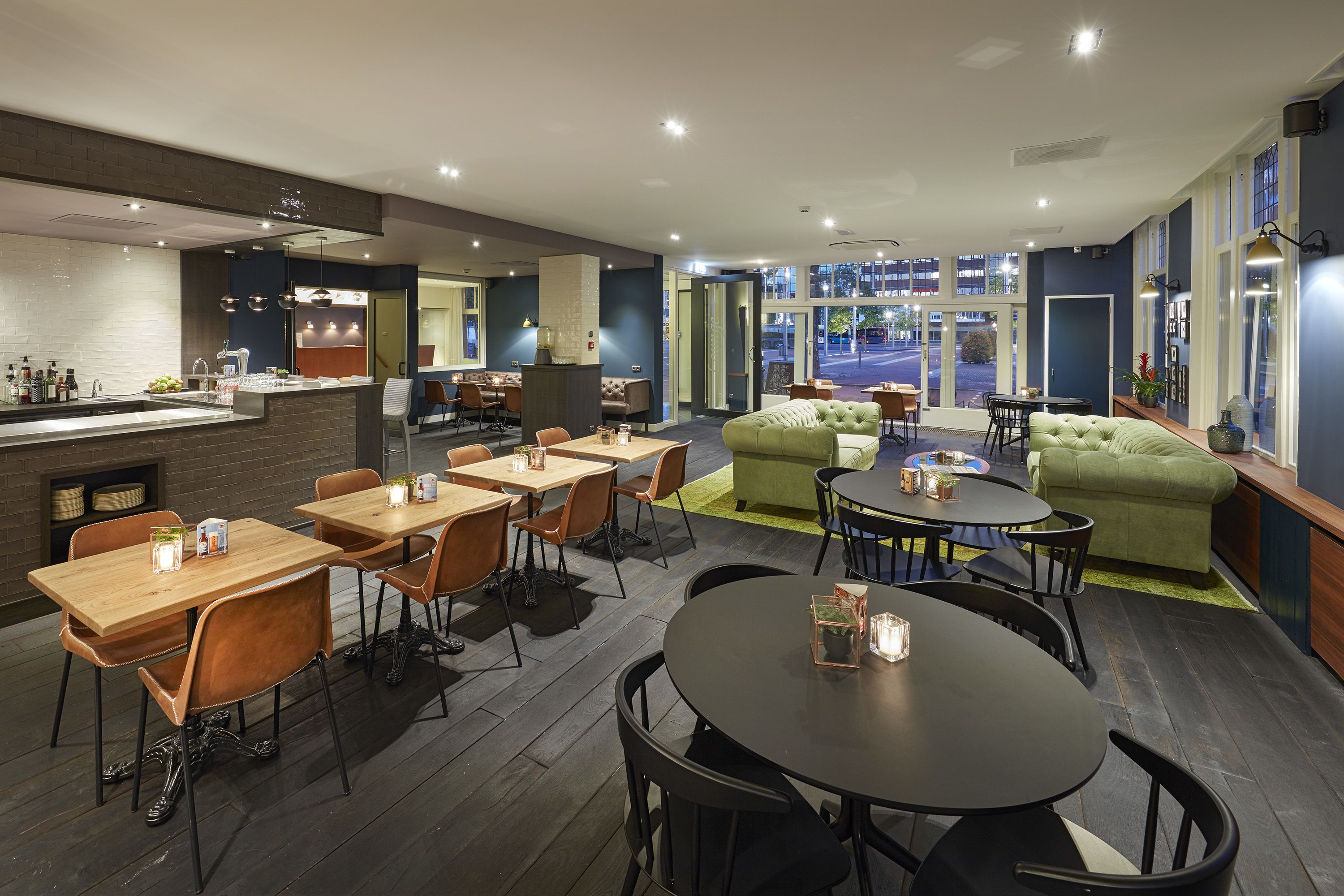 A modern restaurant with a bar area, seating arrangements, and a view of the street.