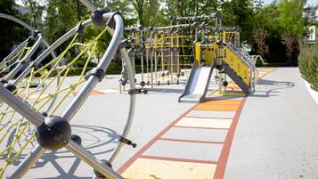 Un parque infantil con estructuras metálicas para escalar y un tobogán.