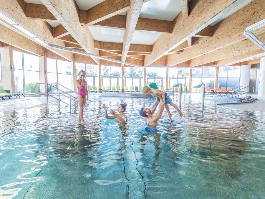 Een binnenzwembad en ligstoelen