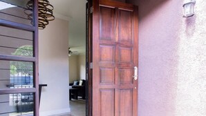 A wooden door with a handle, a glass door with a metal frame, and a wall with a textured finish.