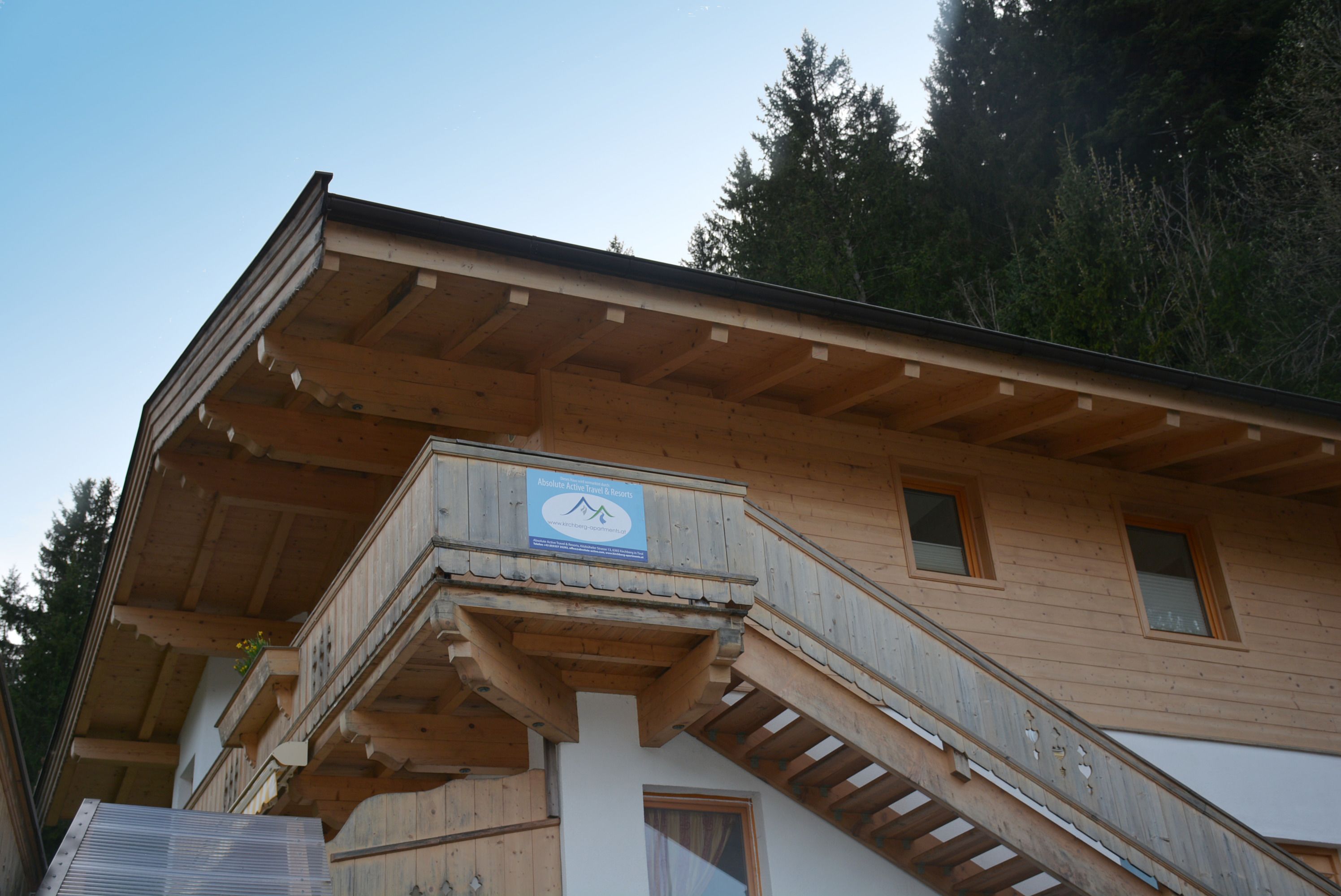 A wooden building with a balcony and a staircase.