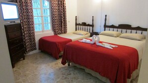 A hotel room with two beds, a television, and a dresser. - Ocean Wave Villa (Negril)