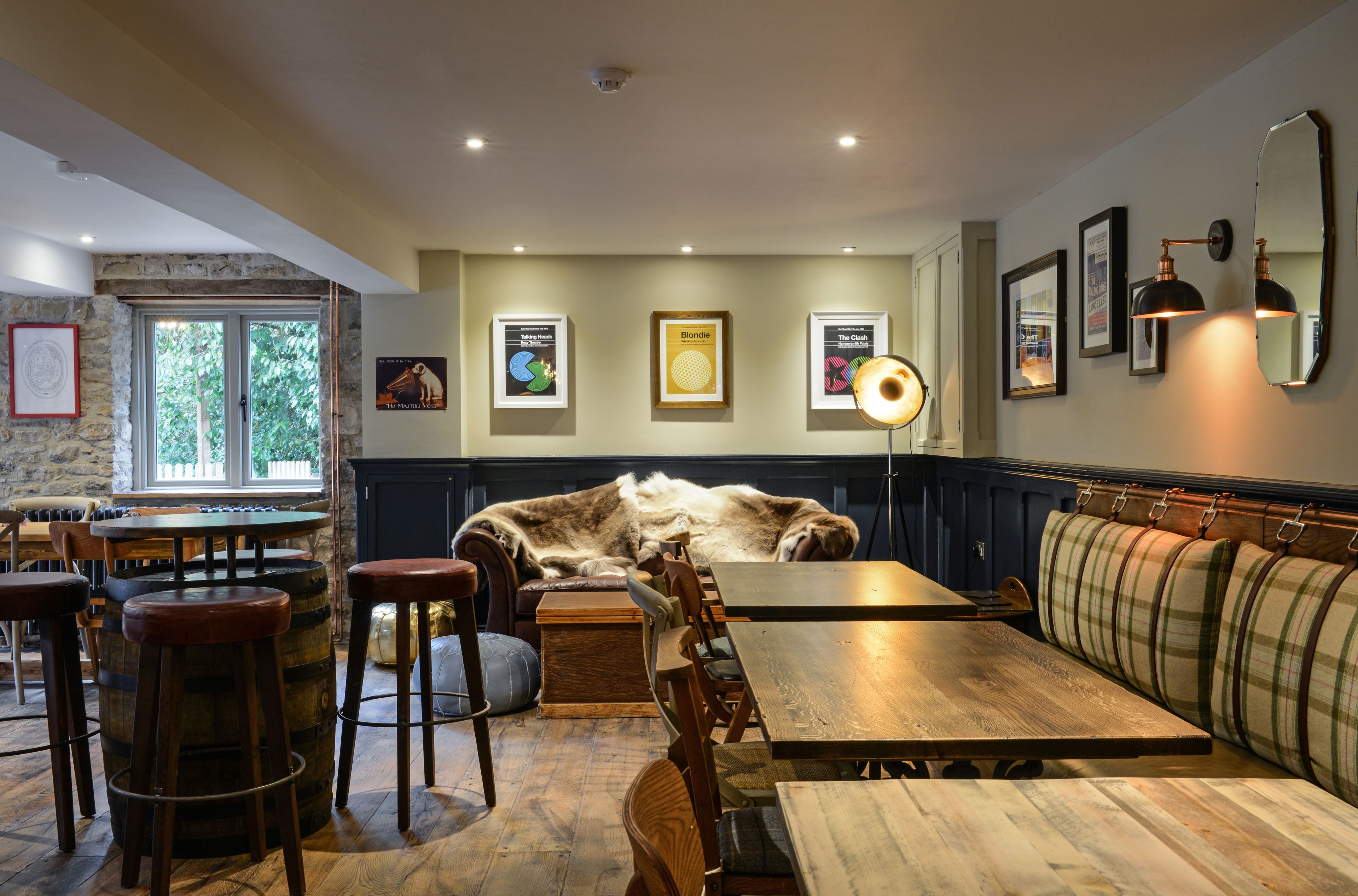 A cozy restaurant interior with wooden furniture, a large dog resting on a bench, and framed artwork on the walls.