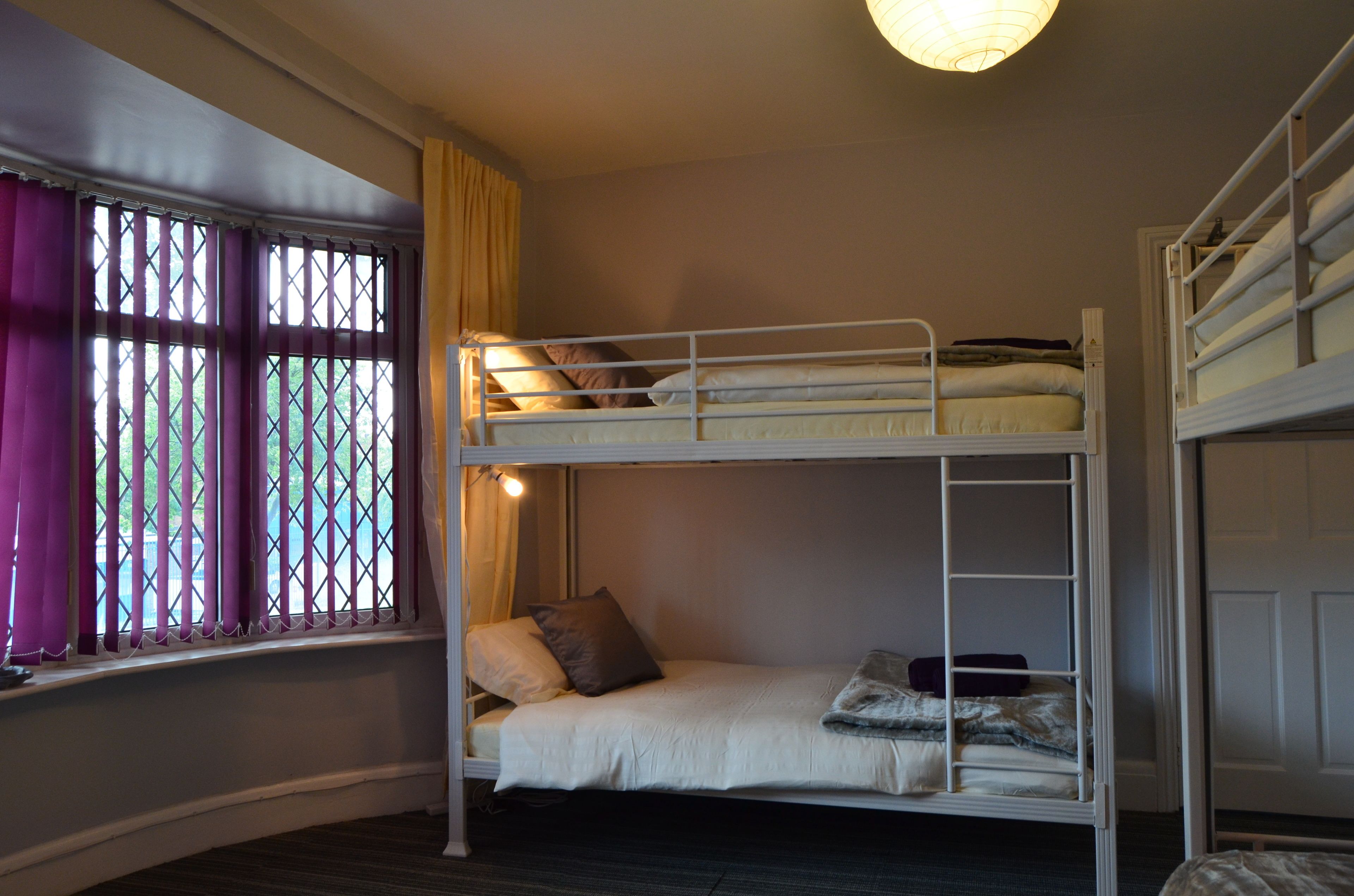 A bunk bed room with a window and curtains.