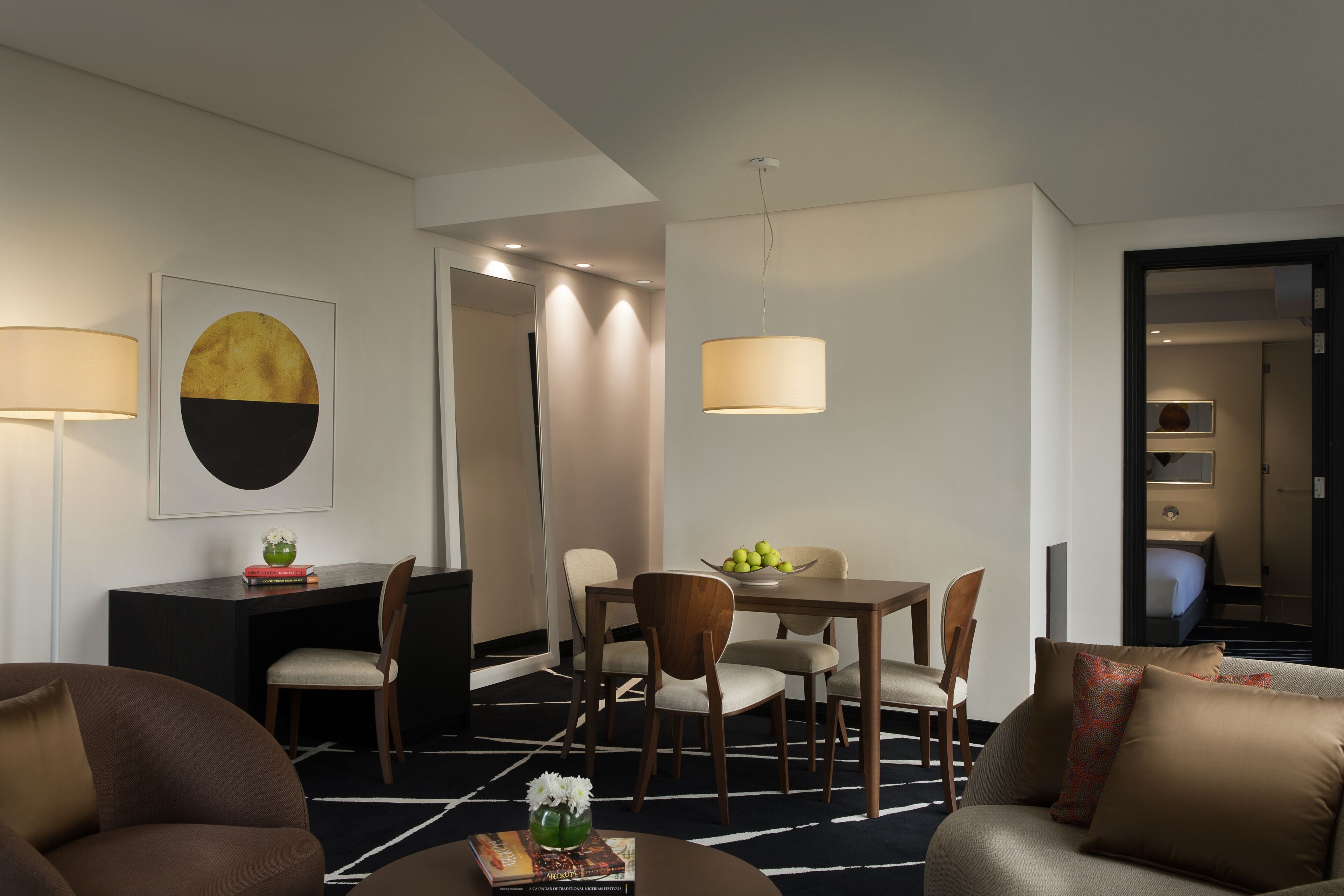 Een moderne hotelkamer met een zithoek, een bank en een bureau.
