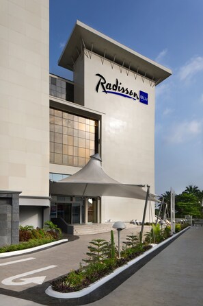 A Radisson Blu hotel with a modern facade, large windows, and a landscaped entrance area. - Radisson Blu Lagos Ikeja Hotel (Lagos)