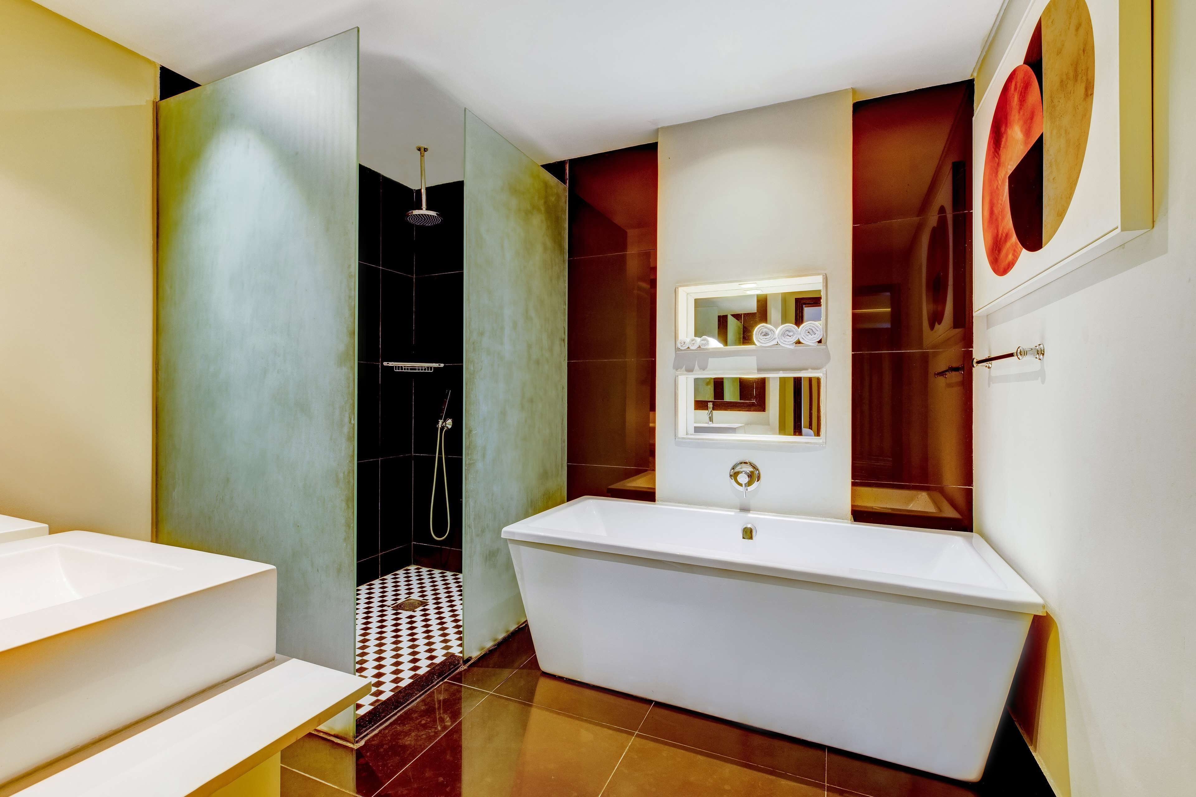 A modern bathroom with a freestanding bathtub, a glass-enclosed shower, and a large mirror with a towel rack.