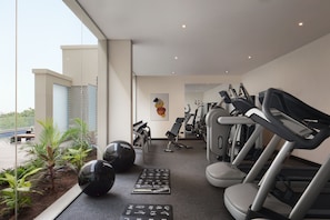 Un gimnasio moderno con cintas de correr, pelotas de ejercicio y diversos equipos de entrenamiento.