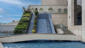 Un edificio moderno con piscina, barandilla de cristal y escalera con azulejos azules.