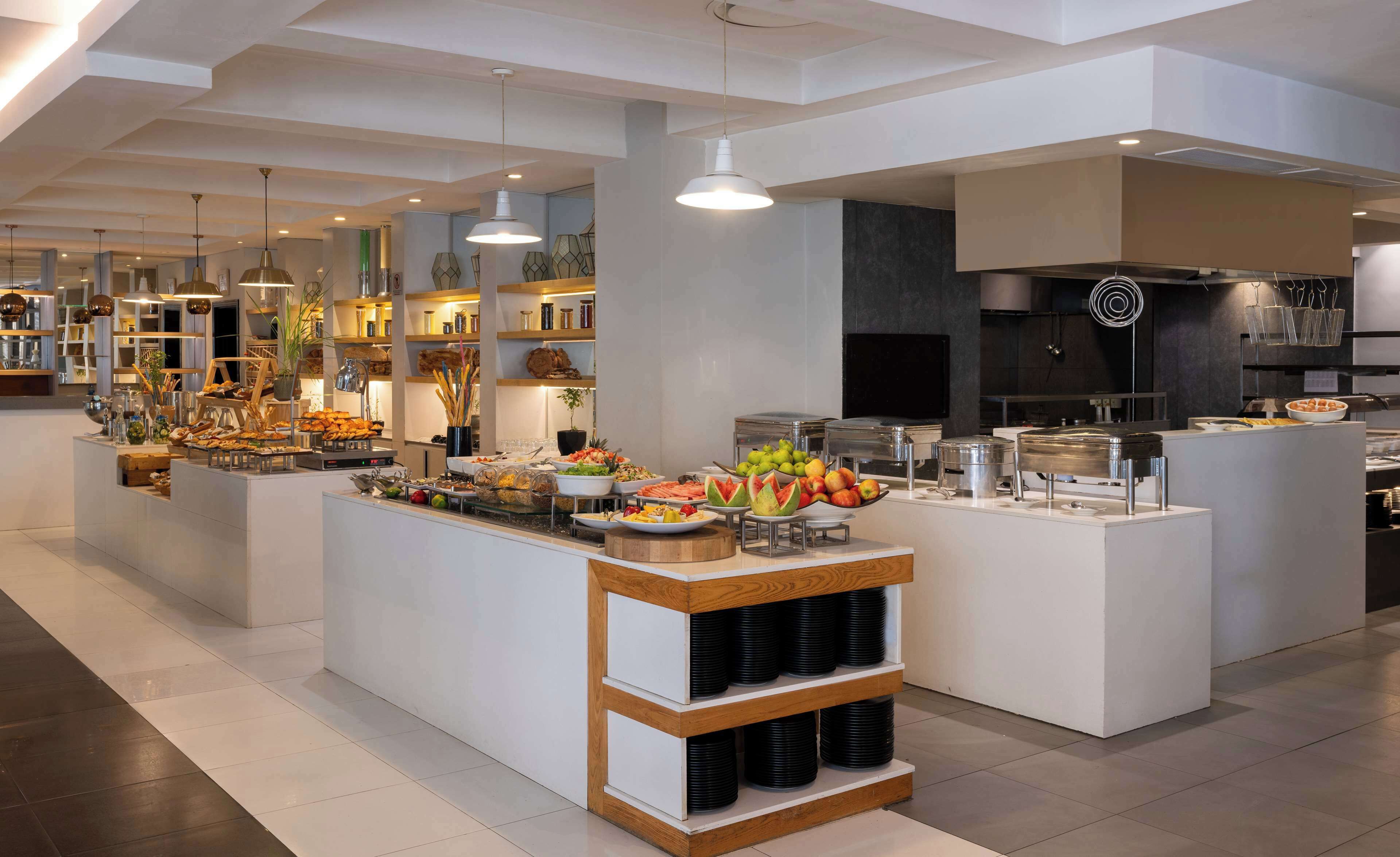 A modern buffet setup with various food items and a coffee station.