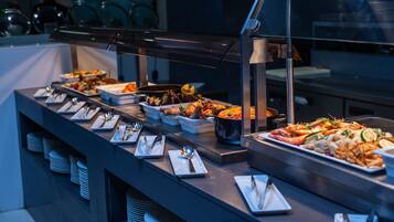 A buffet with various seafood dishes, neatly arranged plates, and a modern kitchen setting.