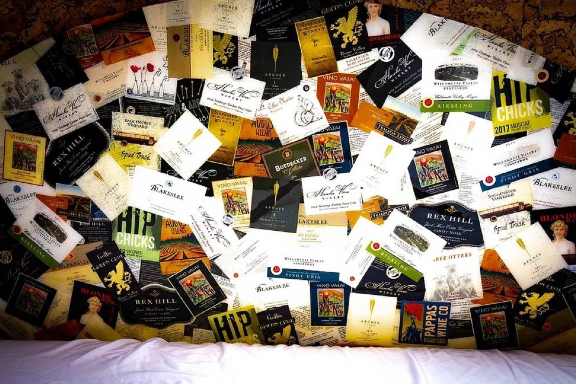 A collection of wine labels and book covers spread out on a surface.
