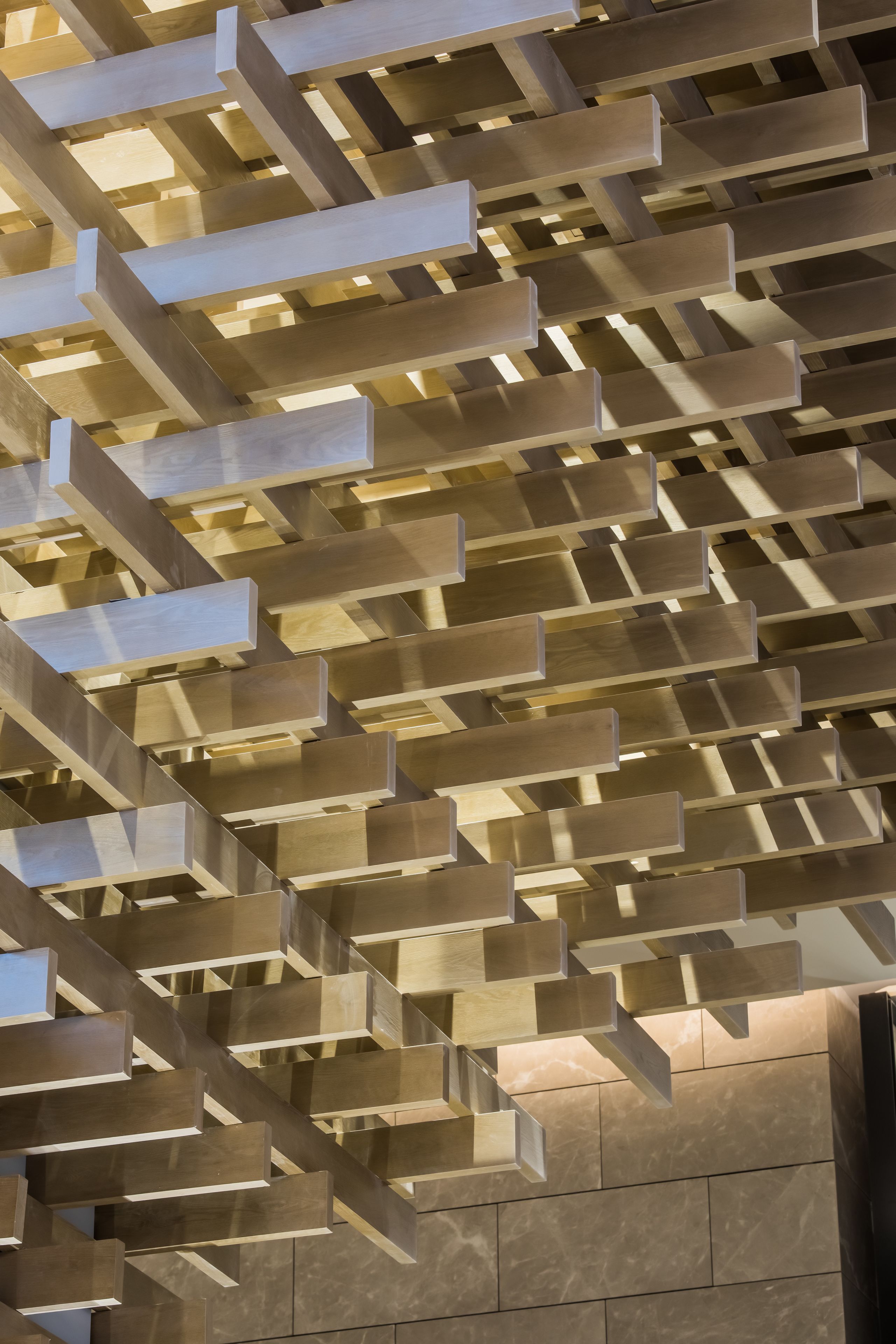 A modern interior with a geometric wooden ceiling design.