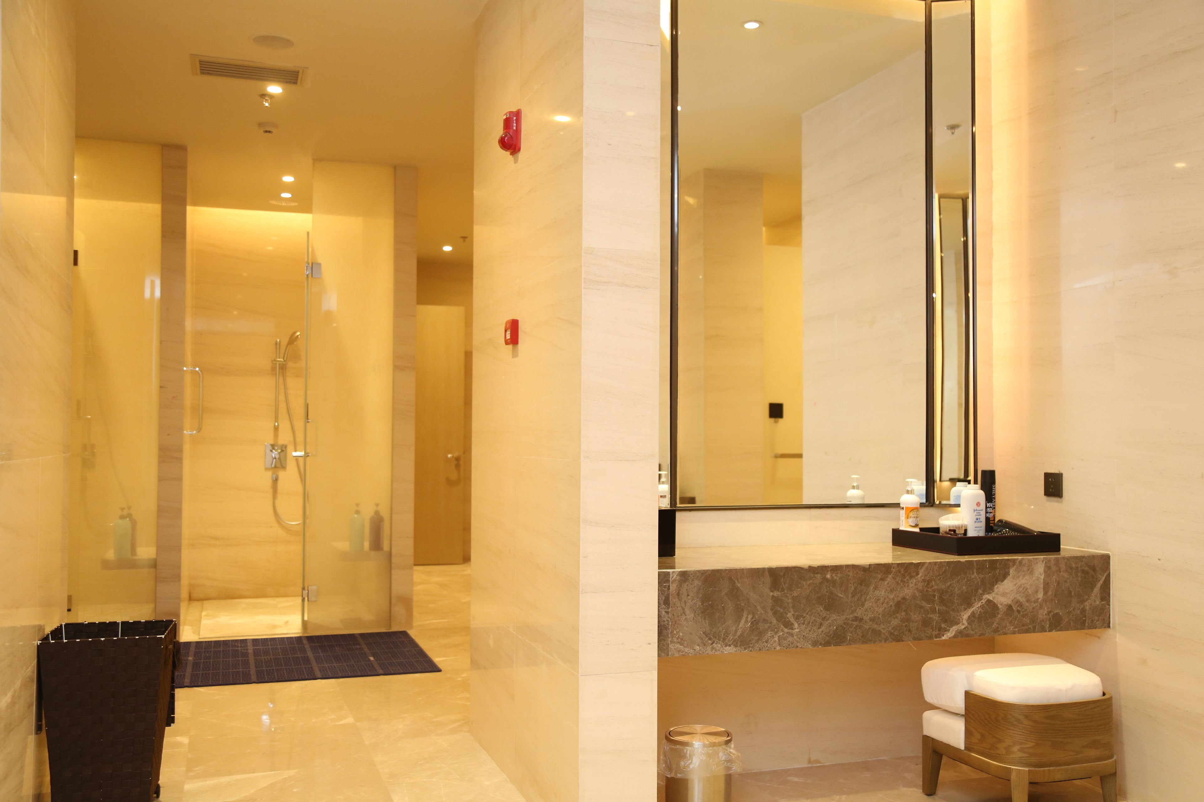 Une salle de bain moderne avec une douche à parois de verre, un meuble-lavabo en marbre et un grand miroir.