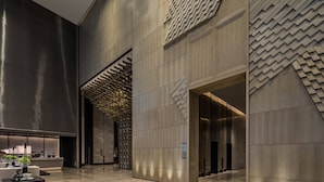A modern lobby with a marble floor, a reception desk, and a patterned wall design. - Chengdu Marriott Hotel Financial Centre (Chengdu)