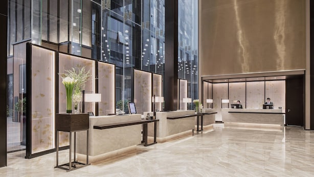A modern hotel reception area with glass partitions, marble counters, and a spacious lobby. - Chengdu Marriott Hotel Financial Centre (Chengdu)