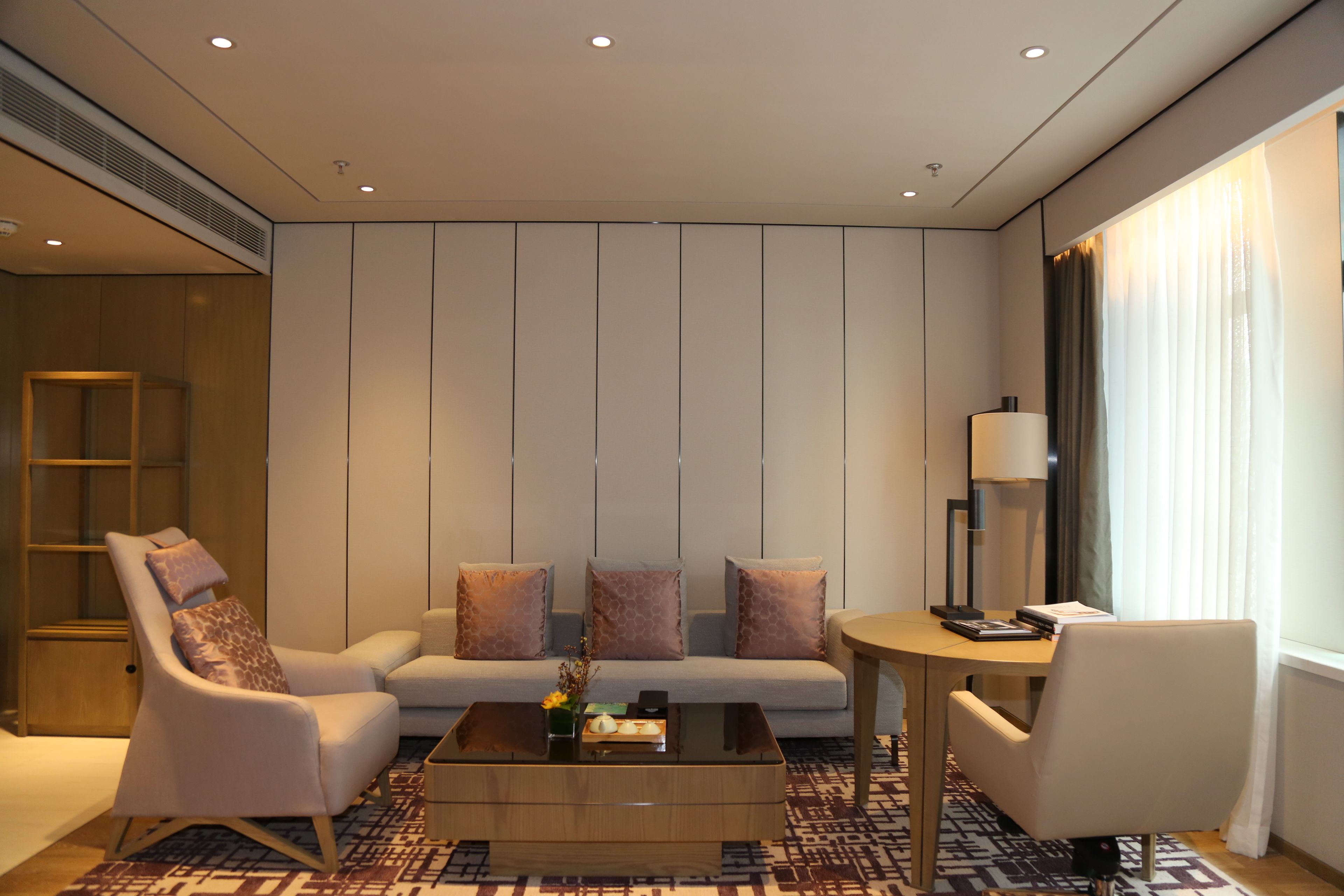A modern living room with a sofa, armchairs, a coffee table, and a dining table.