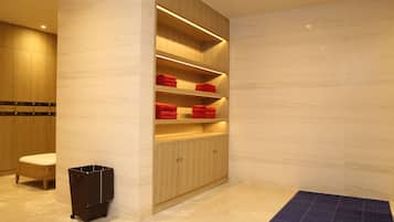 Un baño moderno con suelo de mármol, armarios de madera y una alfombra azul.