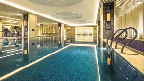 A modern indoor swimming pool with a clear water surface, surrounded by a tiled floor and walls. - Chengdu Marriott Hotel Financial Centre (Chengdu)