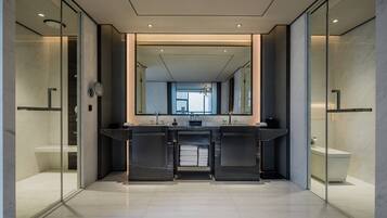 A modern bathroom with a large mirror, two sinks, and a glass shower enclosure.