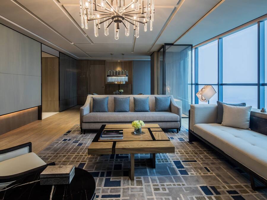 A modern living room with a sofa, a coffee table, and a large window.