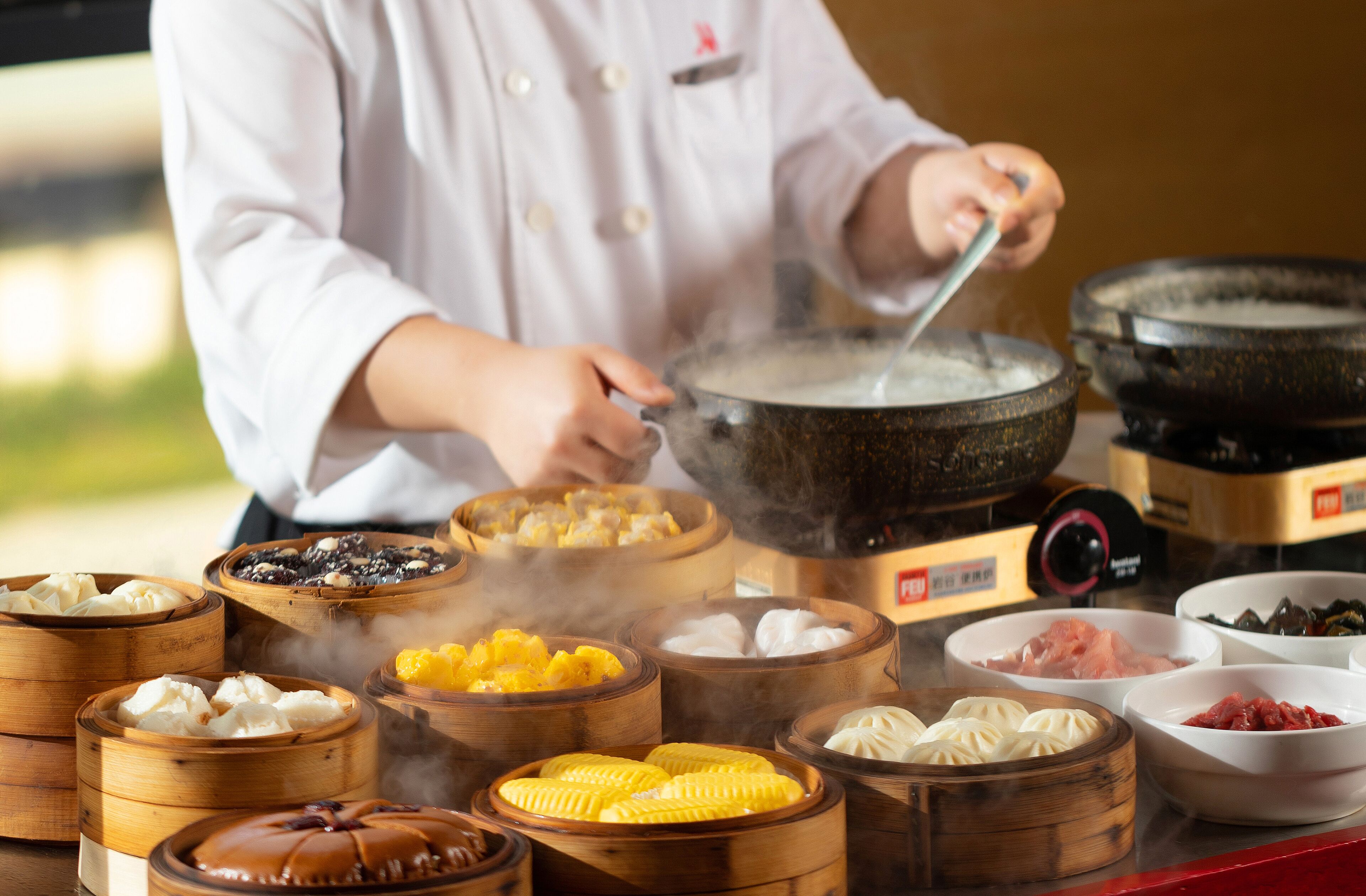 A chef preparing food in a kitchen with various cooking utensils and ingredients visible.