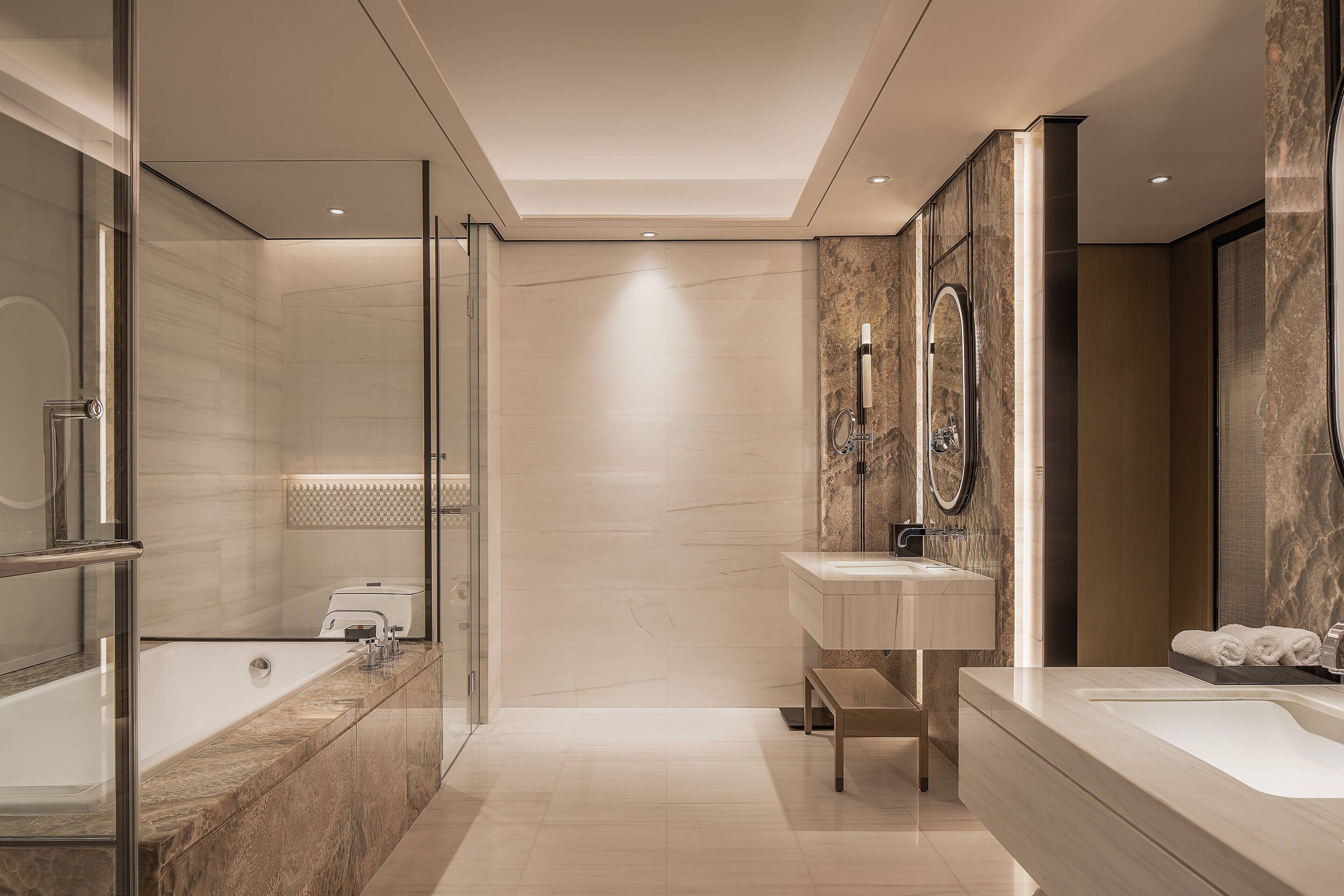 Une salle de bain moderne avec une douche à parois de verre, une grande baignoire et un meuble-lavabo avec un miroir.