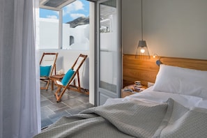 Relax on the balcony with a view of the distant mountain and white building.