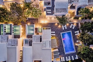 Vista aérea de un hotel con múltiples piscinas, zonas de descanso y una piscina central grande.