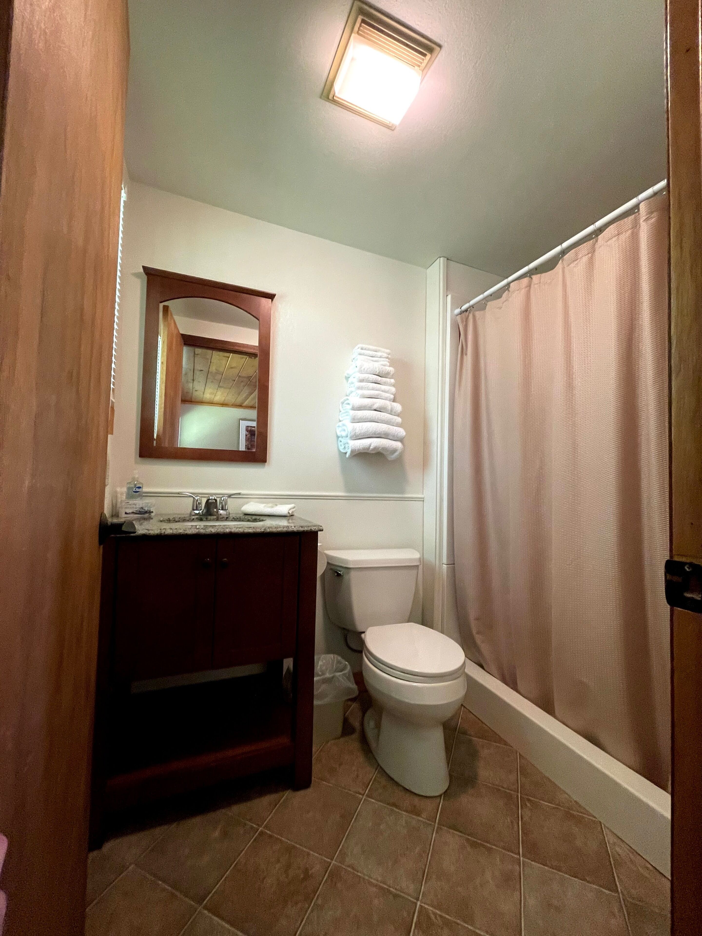 Un baño con inodoro, lavabo y cortina de ducha.