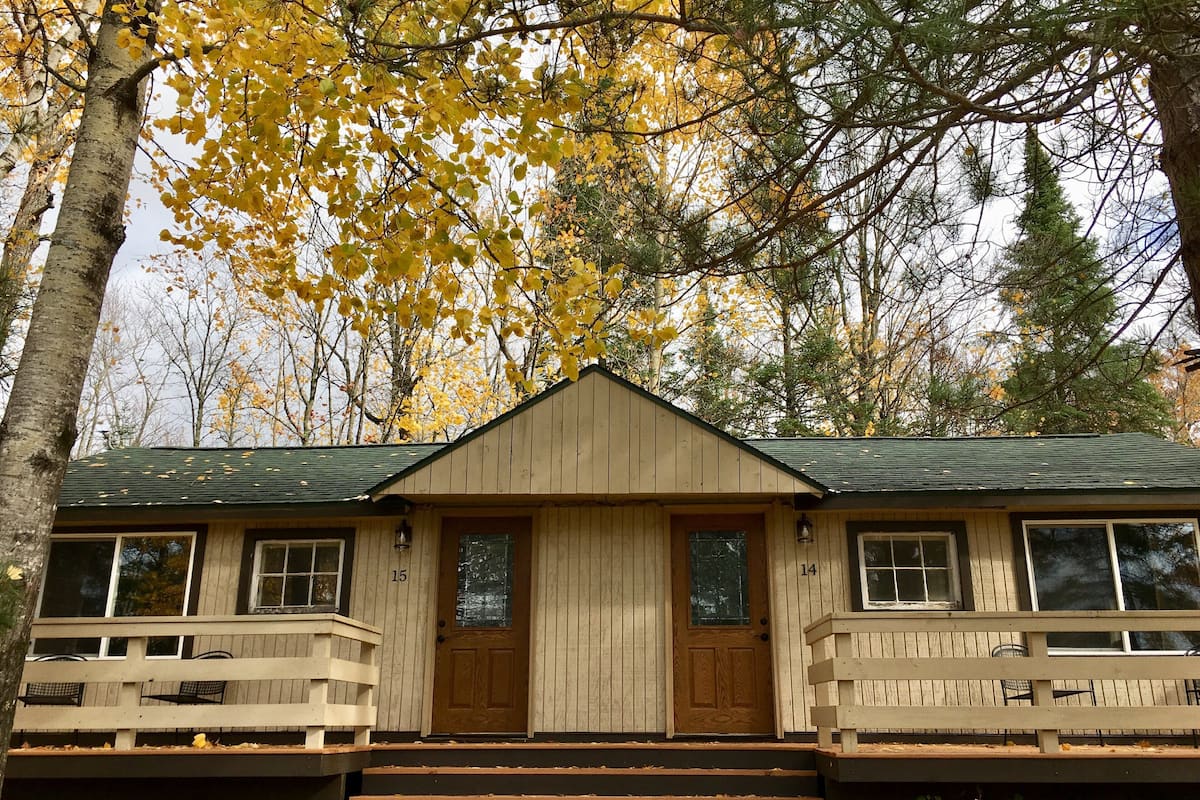 A cabin with a front porch, two doors, and a number 14 on the right.